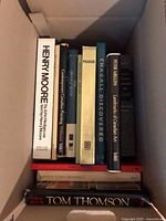 Books standing in open box showing visible spines and two books laid horizontally