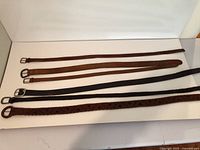 Six belts laid out flat showing full lengths and buckle styles