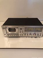 Front view of Apogee A-1800 cassette deck showing cassette well, controls and VU meters