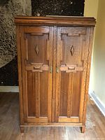 Front view of closed oak wardrobe showing paneled doors and brass hardware
