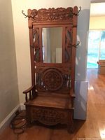 Full view of carved wood hall tree with mirror and hooks