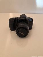 Front view of Minolta SLR camera with attached lens and cap