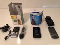 Overall lot showing three phones, two retail boxes and accessories