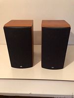 Front view of two PSB bookshelf speakers showing grilles and cabinet finish