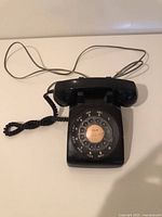 Front view of black Western Electric rotary phone showing rotary dial and handset