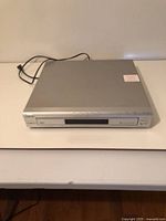 Front angled view of silver Sony 5-disc DVD/CD player on table