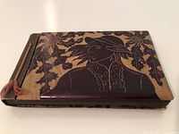 Front cover showing carved folk portrait and foliage design