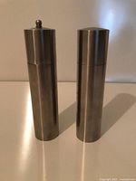 pair of stainless steel cylindrical salt and pepper grinders