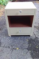 Front view of painted wood two-drawer nightstand showing clear knobs and open shelf