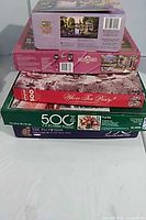 Stack of five boxed jigsaw puzzles