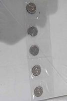 Five coins sealed in plastic strip