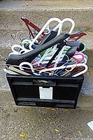 Overall view of black crate filled with assorted hangers