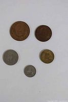 Obverse sides of five coins arranged on white background