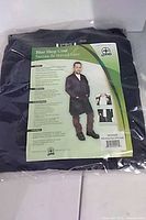 Front of packaged blue shop coat with product insert showing model wearing coat