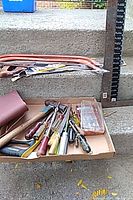 Overview of box with hand tools along with framing square and pry bars visible