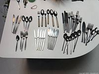 Entire assortment of cutlery laid out on table showing all groupings
