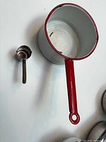 Top view of saucepan and brass measuring cup showing sizes and finishes