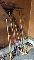 Group shot of all long-handled tools leaning against wall
