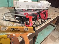 Lot overview showing Skil reciprocating saw, hacksaw, Stanley I-Beam level and part of hand saw