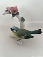 Front left view showing bird, branch and flower