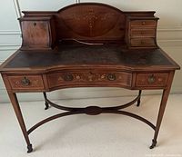 Front view of mahogany writing desk showing overall form and inlay