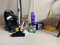 Group shot showing vacuum, Swiffer mop, duster, consumables and manual