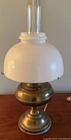 Full view of lamp with brass base and white glass shade