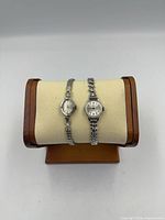 Both watches on display cushion, front view