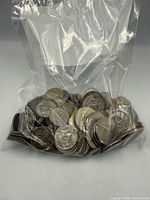 Clear plastic bag filled with mixed U.S. coins, view of fronts and edges