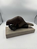 Profile view of bronze beaver on stone base
