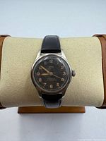Front view of Birks Eterna watch on display cushion showing dial, case and leather strap