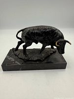 Front angled view showing entire bronze bull and marble base