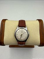 Front view showing dial, case, leather strap