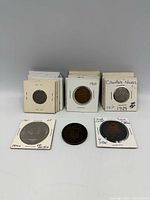 Stacks of Canadian coins in flips with loose tokens front