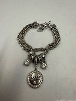 Full view of Guess silver-tone rope chain bracelet with charms
