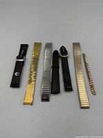 Front view of all seven watch bands laid out side by side