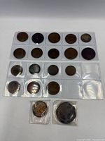 Front view of all coins in plastic pocket pages and two bagged coins