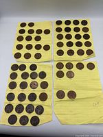 Four sheets of yellow lined paper holding rows of Canadian pennies