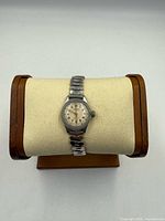 Full view of Marathon wristwatch on display pillow, showing stainless case and stretch band