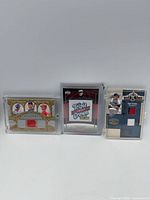 Three memorabilia relic cards with jersey/patch pieces