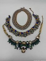 All three necklaces laid out, showing chain styles and decorative fronts