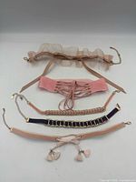 Five choker necklaces laid out showing designs and hardware