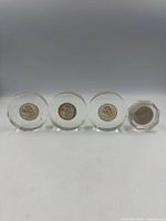 Four coins in acrylic mounts