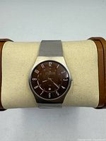 Front view of watch on display pillow showing dial and mesh band