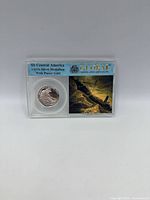 Front of sealed holder showing silver medallion and ship image