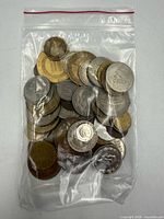 Clear plastic bag containing a variety of world coins
