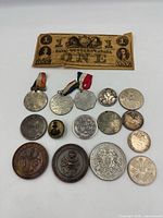 Overview of banknote, ribboned medals, assorted medals, tokens and pin
