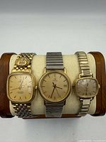 Front view of three Omega wristwatches on stand