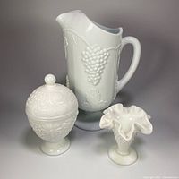 Group shot of all three milk glass items: pitcher, vase, lidded candy dish