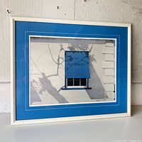 Overall view of framed print in white frame with blue mat